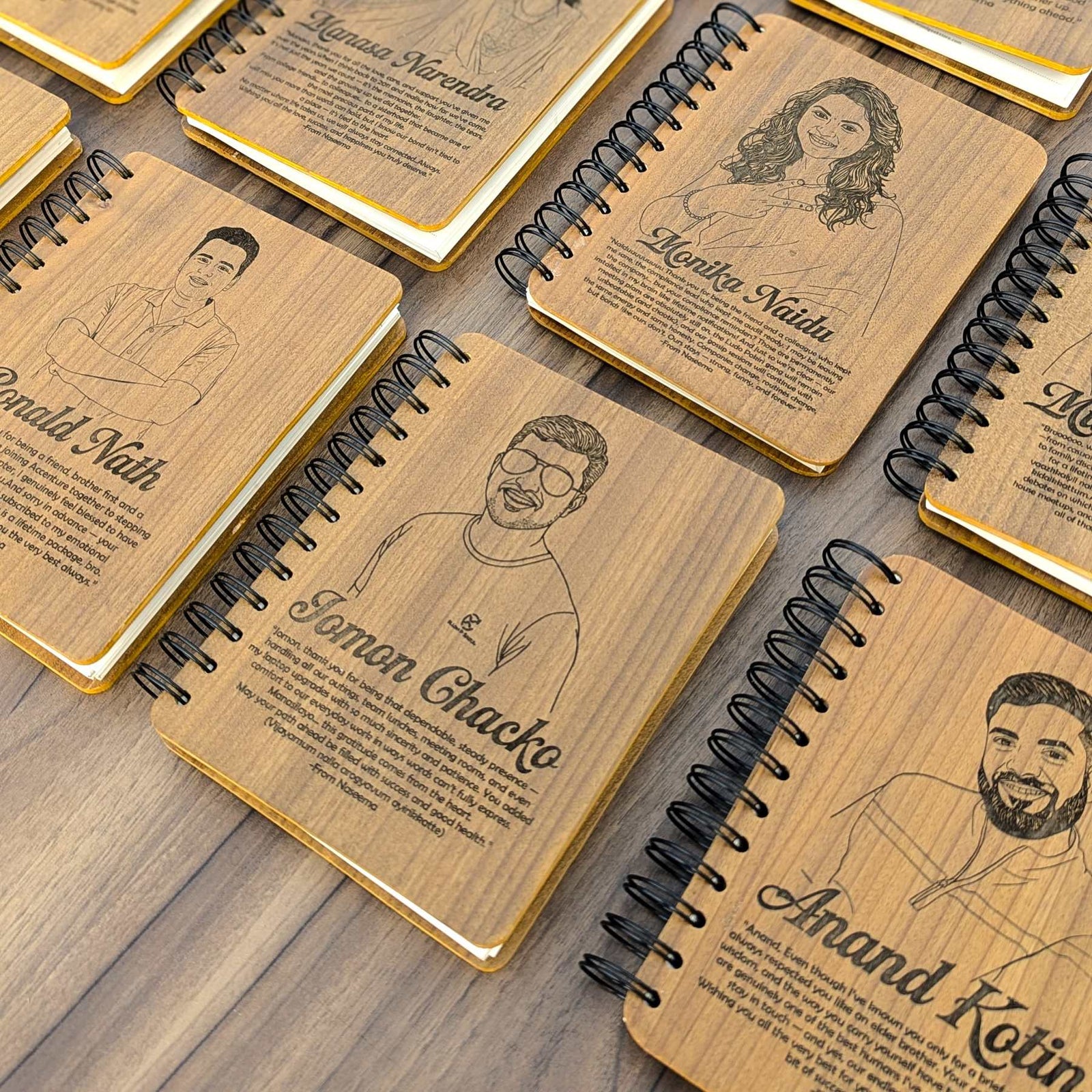 Wooden notebooks and diaries with engraved portraits and names and personalized message on a wooden surface made for a corporate gift set 